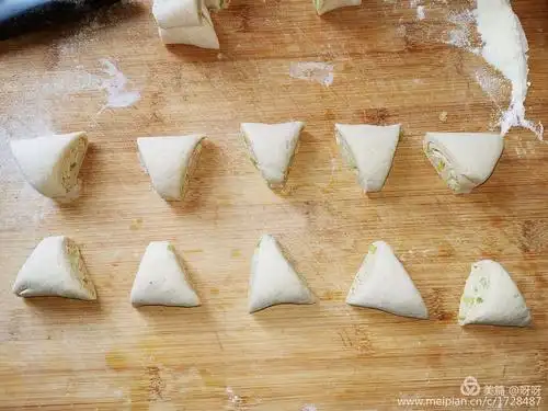三,随便从一边开始将面片卷起来,并切成均匀的三角形剂子,如图示.