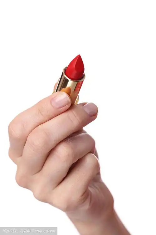 手里拿着红色口红的女人.美丽与时尚概念