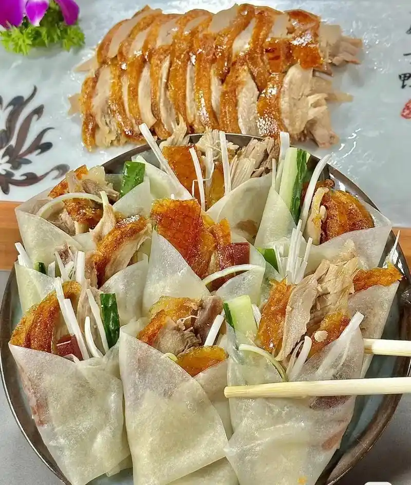 北京片皮烤鸭是北京著名传统的美食之一,鸭皮金黄酥脆,肉质鲜嫩 - 抖