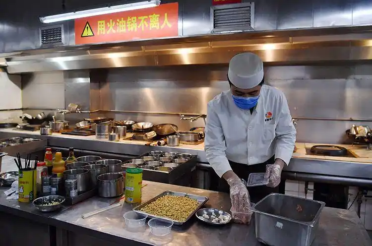 烤肉季后厨,厨师在制作外卖菜.