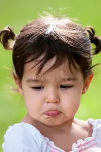 在户外撅嘴的小女孩摄影图