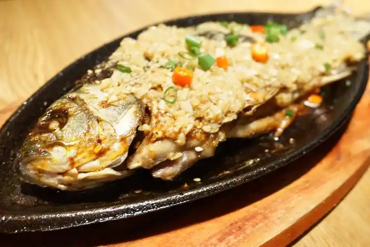一整只烤鱼,香喷喷地,撒上蒜蓉,入味三分,鱼肉细嫩,刺少,铁板烤制