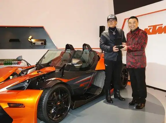 灿辉国际集团董事长赵辉(右)将ktm x-bow gt车钥匙交给首位车主周立波
