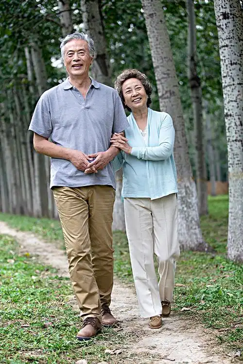 在公园散步的恩爱老夫妻