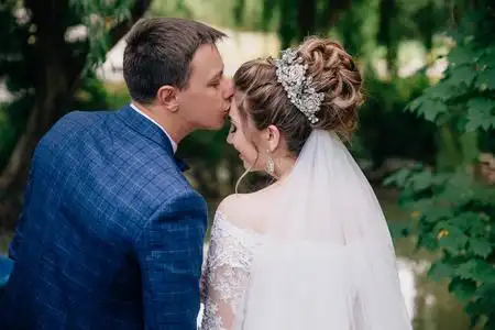 一个男人的后视图轻轻地亲吻他的新娘额头上.