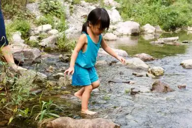 在清澈的小河里玩水的小女孩