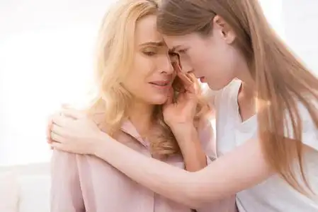 他们坐在家里的沙发上.青少年拥抱她的母亲照片