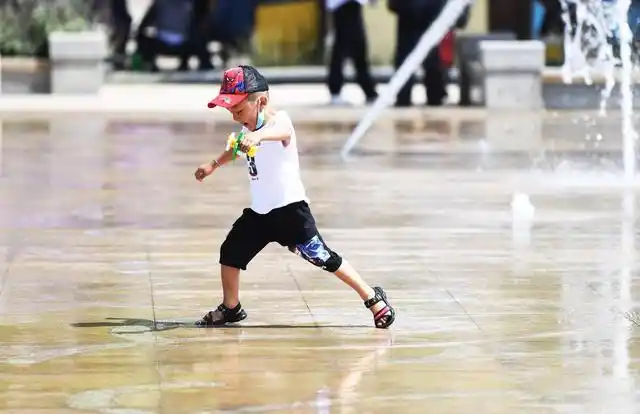 一名小朋友在新疆和田玉石中心玉石产业园玉石交易市场喷泉广场戏水