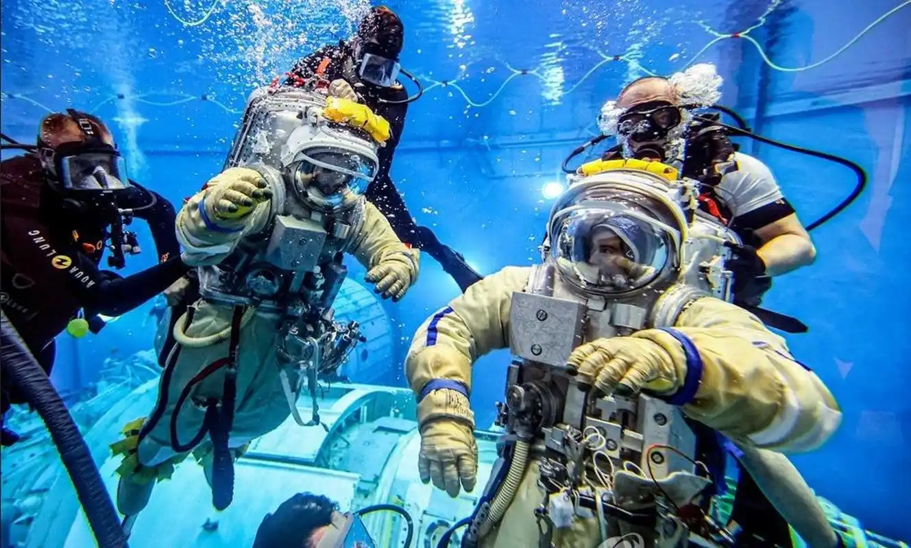 中轮)和身着潜水服的工作人员在加加林宇航员训练中心的中性浮力实验