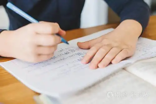 小学生在家里的桌子上用乌克兰语做数学作业男孩把数字分成一列家庭