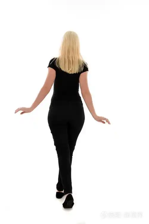 穿黑色衣服的女孩的全长肖像.站立的姿势在白色演播室背景