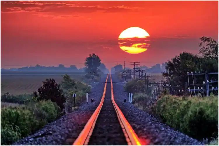 摄影师每年蹲守拍摄被日出染红的铁轨