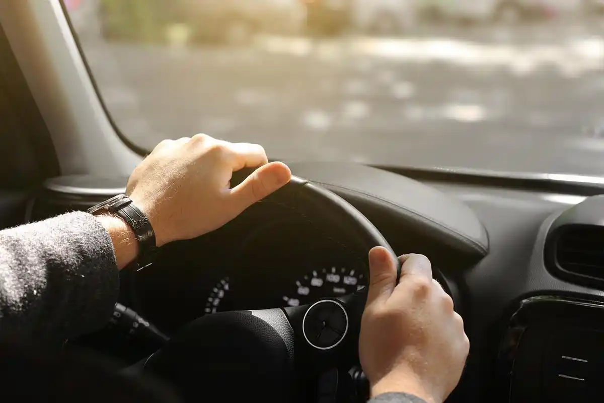 男人手握方向盘司机开车汽车方向盘开车驾驶上路