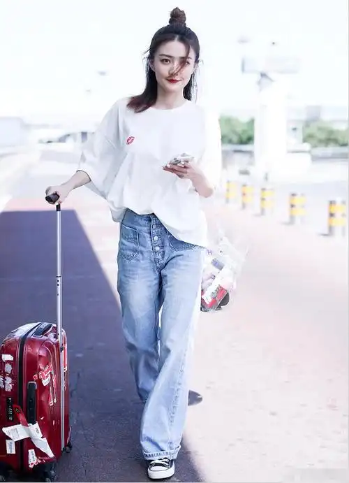 胸前红唇的设计显得特别的时尚,搭配一条浅蓝色的阔腿牛仔裤尽显徐璐