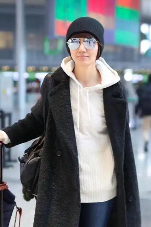 袁泉这种穿衣风格真有国际范黑色大衣配卫衣再戴毛线帽来提亮