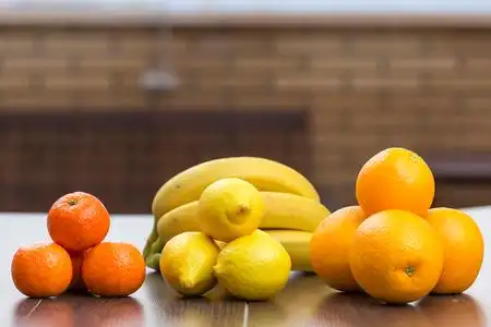 三桩三桩分离柑橘类水果,橘子,橘子和柠檬的视图, 后面是一簇香蕉, 在