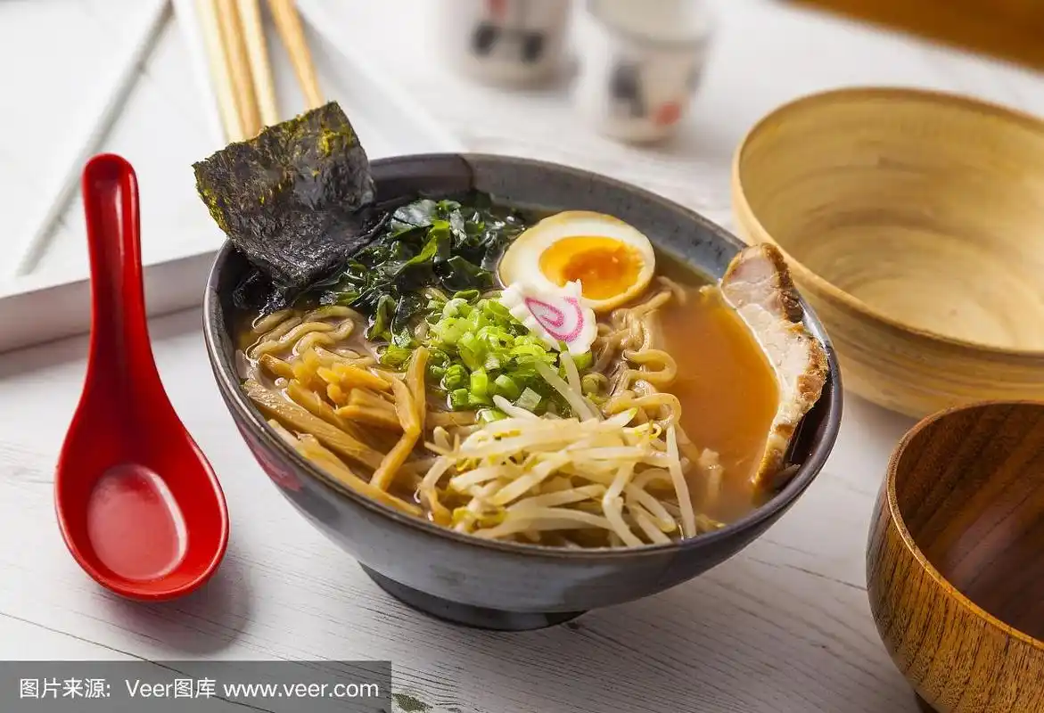 味增拉面亚洲面条与肉和鸡蛋在碗在白色木制背景.