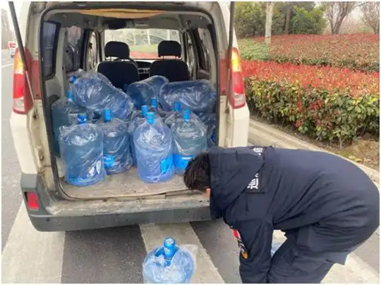 巡防队员和司机急忙行动,把散落在机动车道的桶装水全部搬到了路边