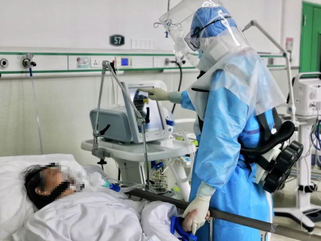徐昉一只手握着患者的手,一只手调整呼吸机一名重症患者出院时对团队