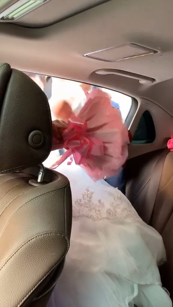 美丽的新娘被抱上了婚车,细心的她赶紧帮新郎收拾好座位!