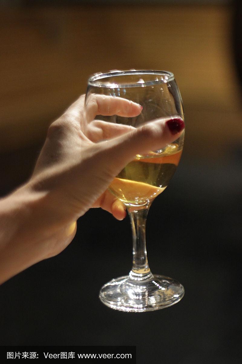 年轻的金发女人拿着一杯白葡萄酒