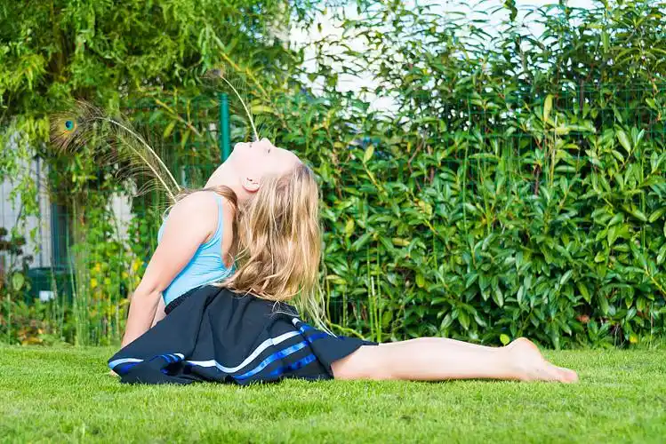 小女孩在花园里做芭蕾舞练习图片下载